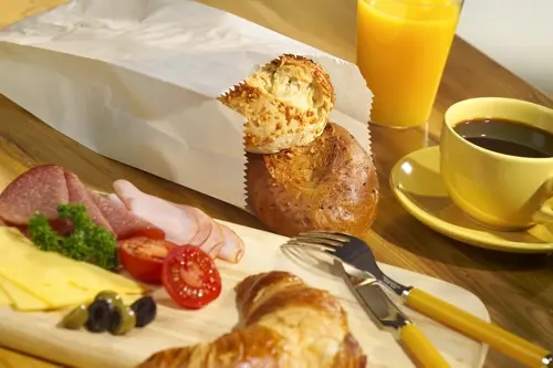 PAPSTAR Papierfaltenbeutel 24x10x5 cm weiß aus Cellulose, gefädelt, befüllt mit Brötchen auf Frühstückstisch, Füllinhalt 0,75 kg, Art.-Nr. 11531