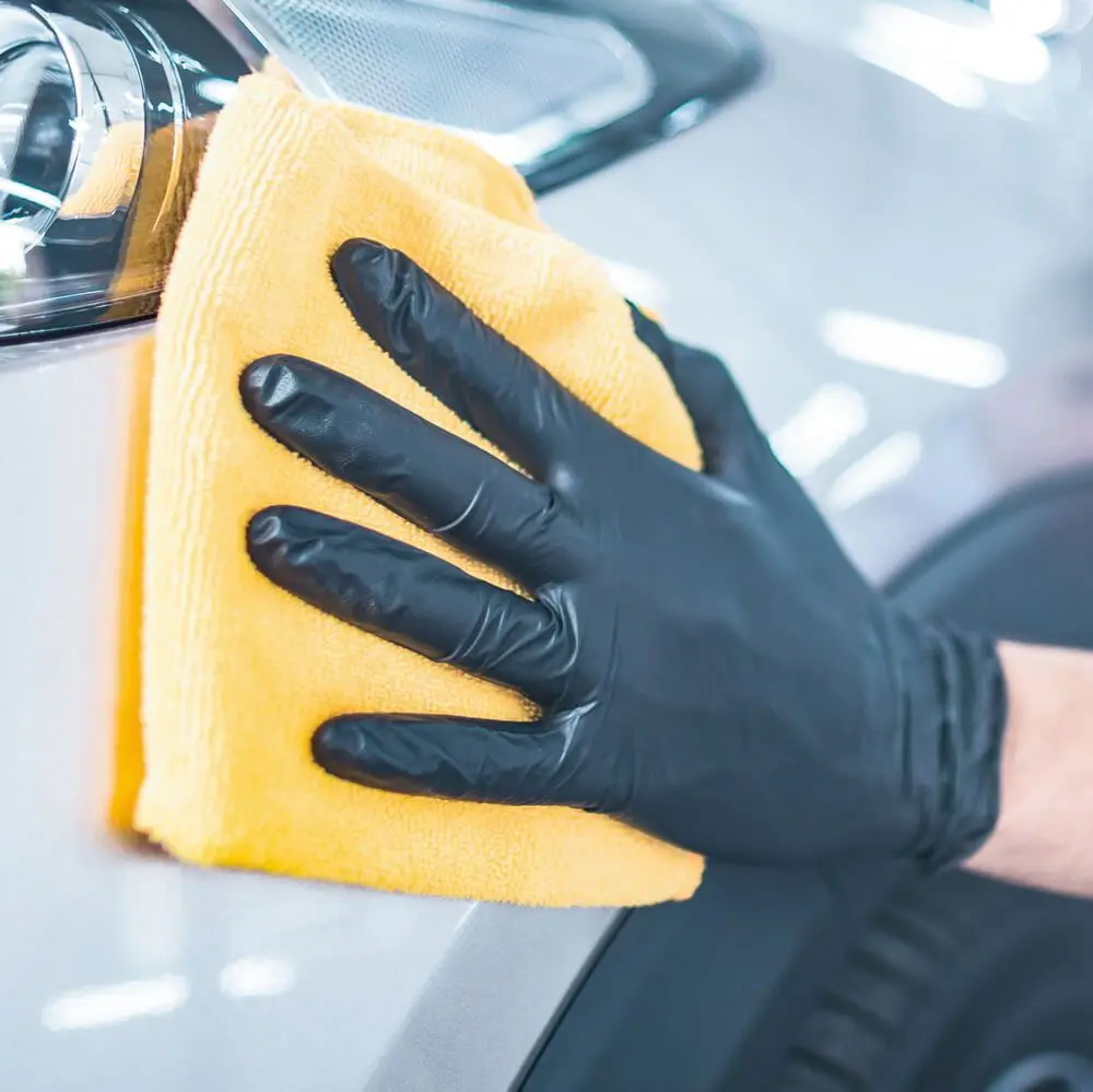 Hygostar Safe Light Nitrilhandschuhe schwarz puderfrei, VE 1000 Stück – schwarze Nitrilhandschuhe beim Reinigen eines Autoscheinwerfers mit gelbem Tuch