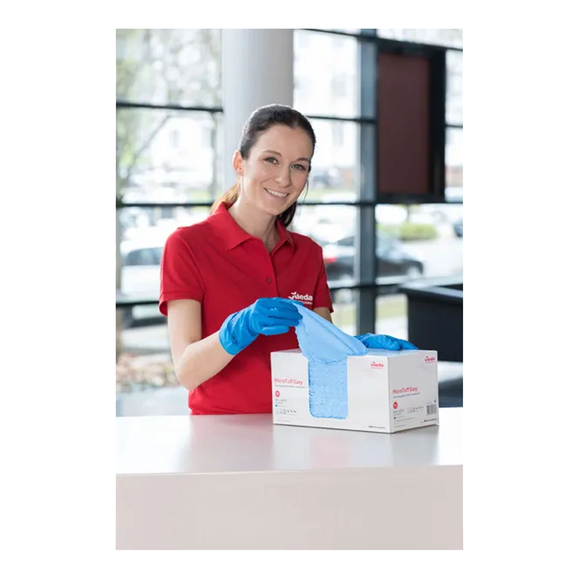 Vileda Microfasertuch MicroTuff Easy, 50 Stück in der Box, Mitarbeiterin entnimmt blaues Microfasertuch für die effiziente Reinigung