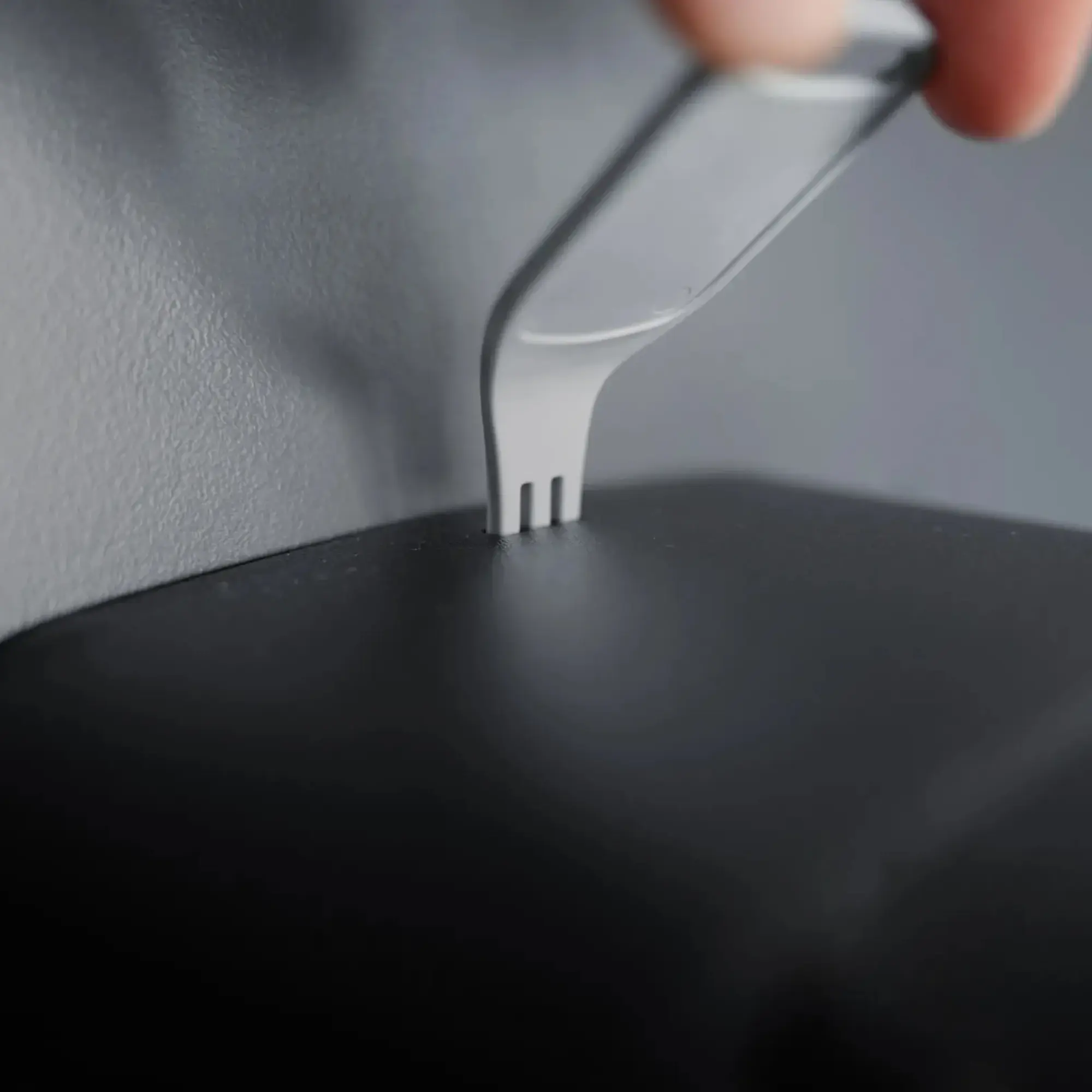 Schwarzer Wandseifenspender mit schlankem Gehäuse zur Wandmontage, Vorderansicht eines modernen Seifenspenders mit glatter Oberfläche