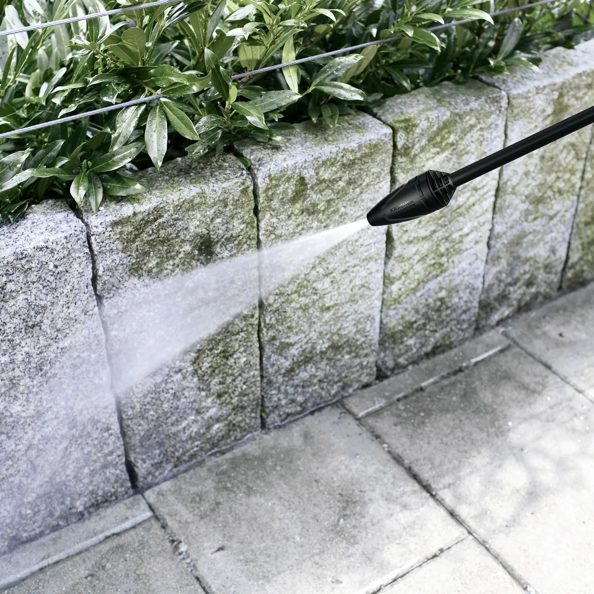 Kärcher K 4 Power Control Flex Hochdruckreiniger entfernt mit Hochdruckstrahl Schmutz von einer Steinmauer und Terrassenplatten, Artikelnummer 1.324-030.0