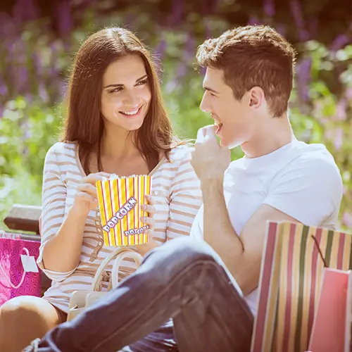 PAPSTAR Popcorn Tüten, Pergament-Ersatz 1,3 l, fettdichte Popcorn-Tüte im gelb-rot gestreiften Kino-Look in der Hand eines Paares, Art.-Nr. 86616