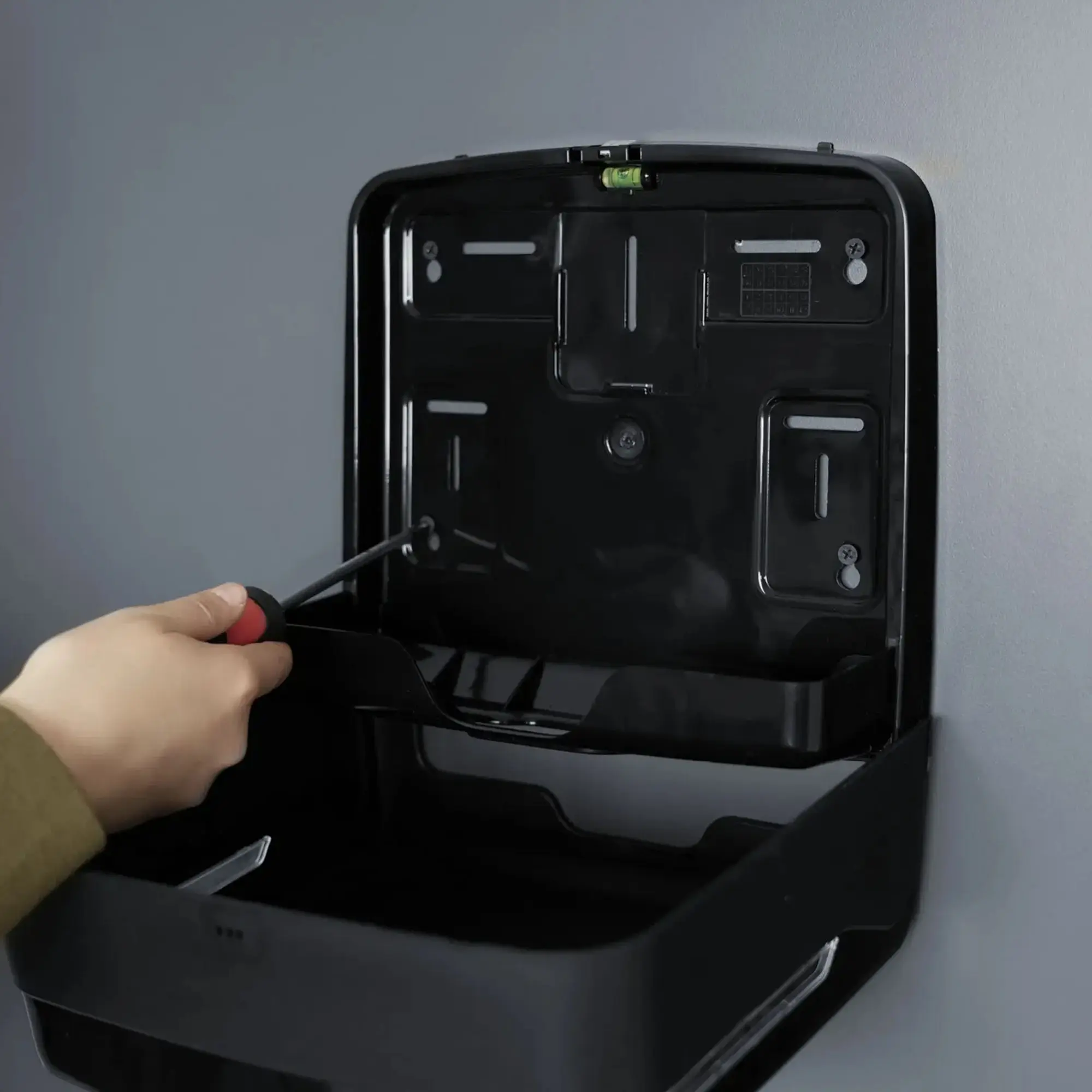 SEMYtop Handtuchspender Mini, Interfold in Schwarz, geöffneter Handtuchpapierspender aus robustem Kunststoff, zeigt einfache Wandmontage mit Schraubenzieher